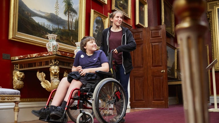 Two visitors exploring the picture gallery at Attingham Park, Shropshire, one is in a wheelchair